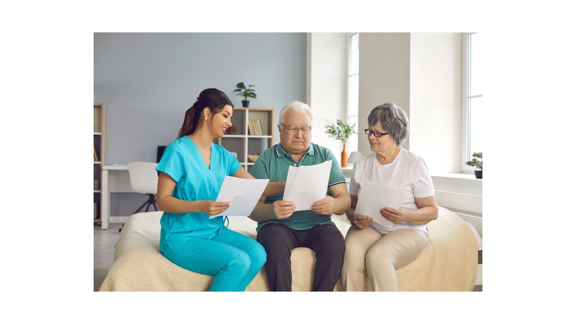 A nurse is sitting on a couch talking to two elderly people.
