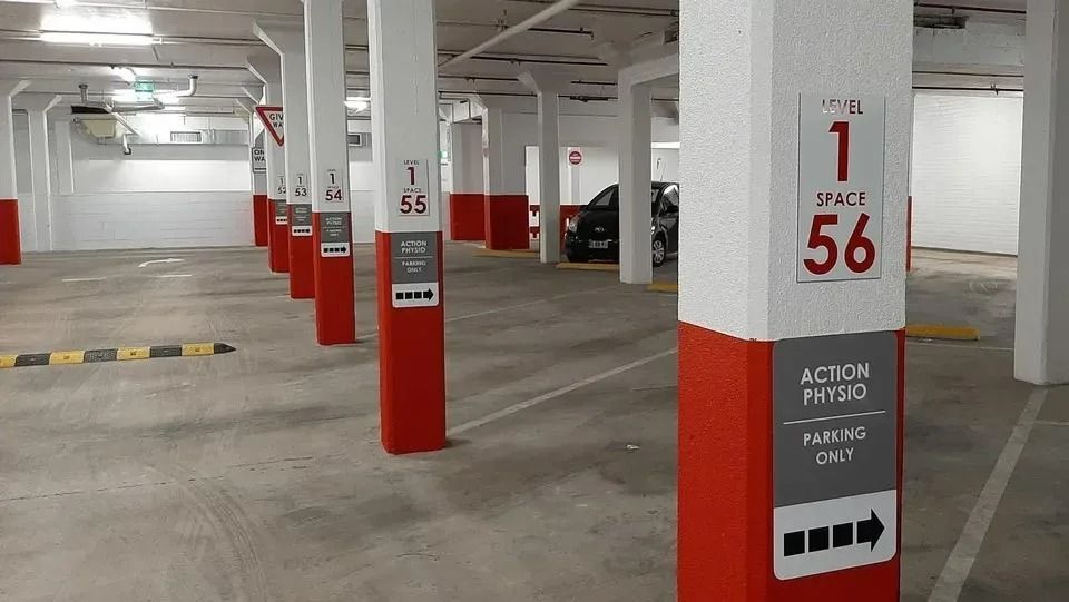 A Row of Red and White Pillars in A Parking Garage — Action Physiotherapy in Cooks Hill, NSW