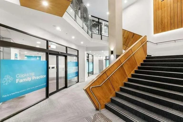 A Staircase Leading up To a Building with A Wooden Railing — Action Physiotherapy in Cooks Hill, NSW