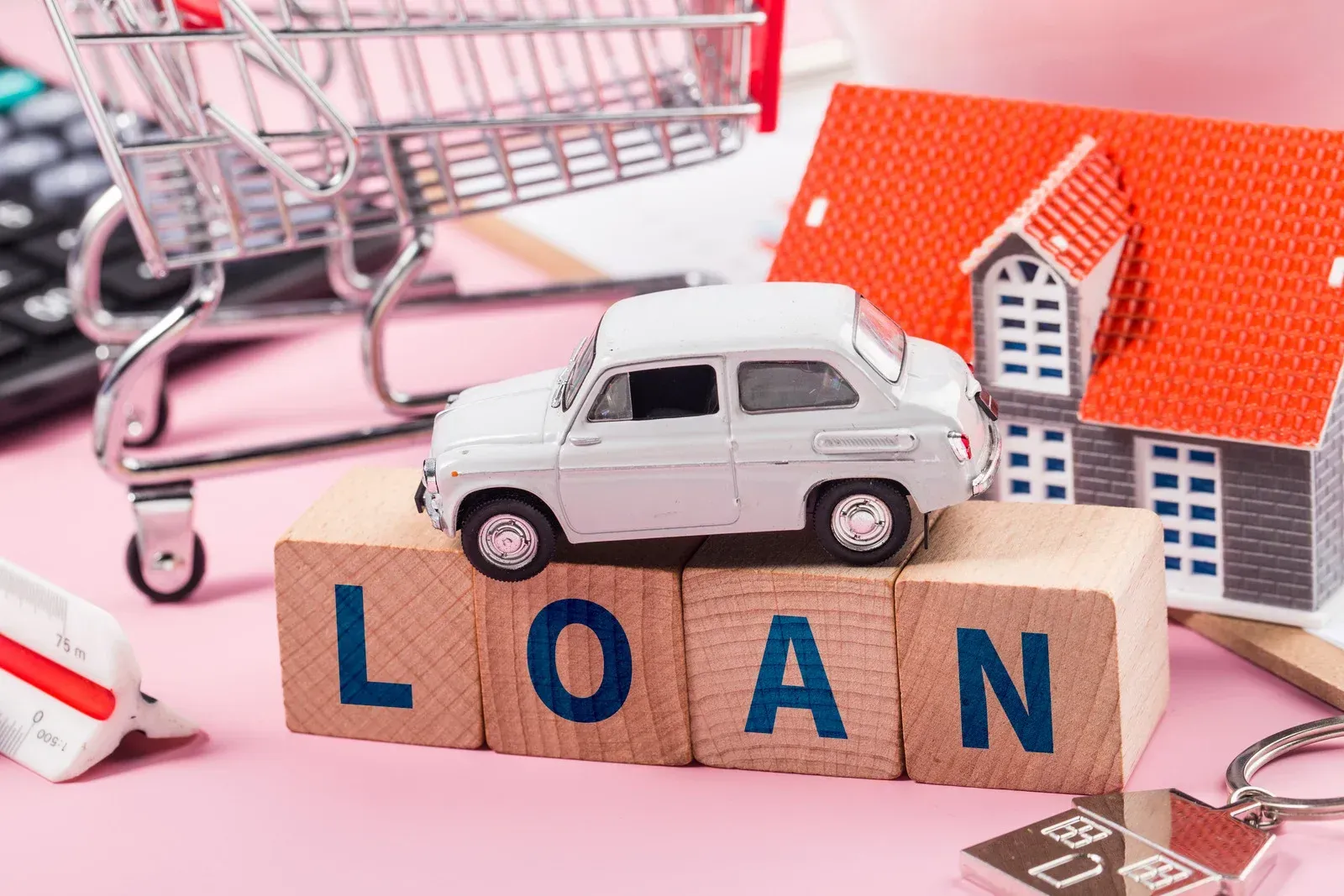 A white toy car rests on wooden blocks spelling