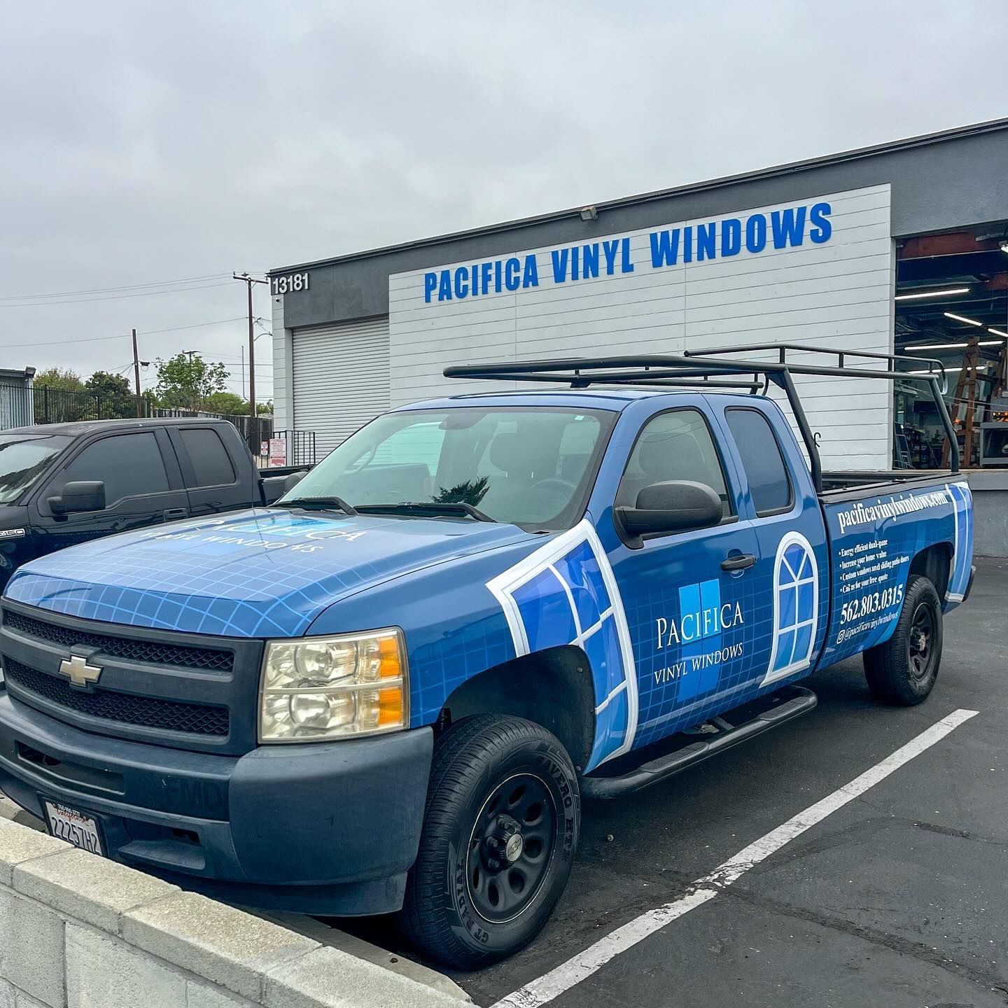 Blue service pickup truck parked outside Pacifica Vinyl Windows building