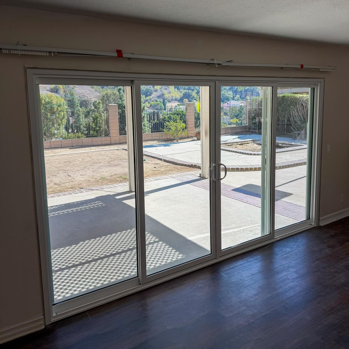 Interior room with large sliding glass doors opening to a sunny patio and garden.
