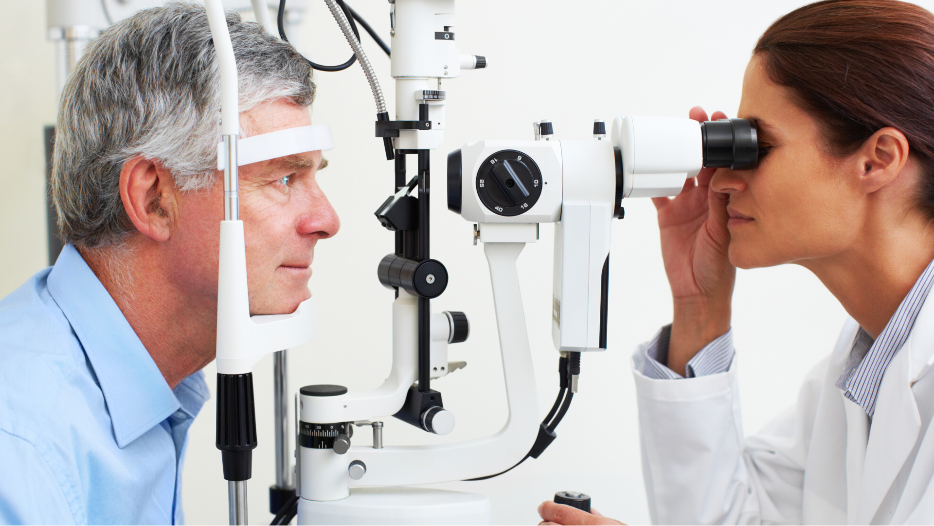 Optometrista examinando os olhos de um paciente  em um consultório.