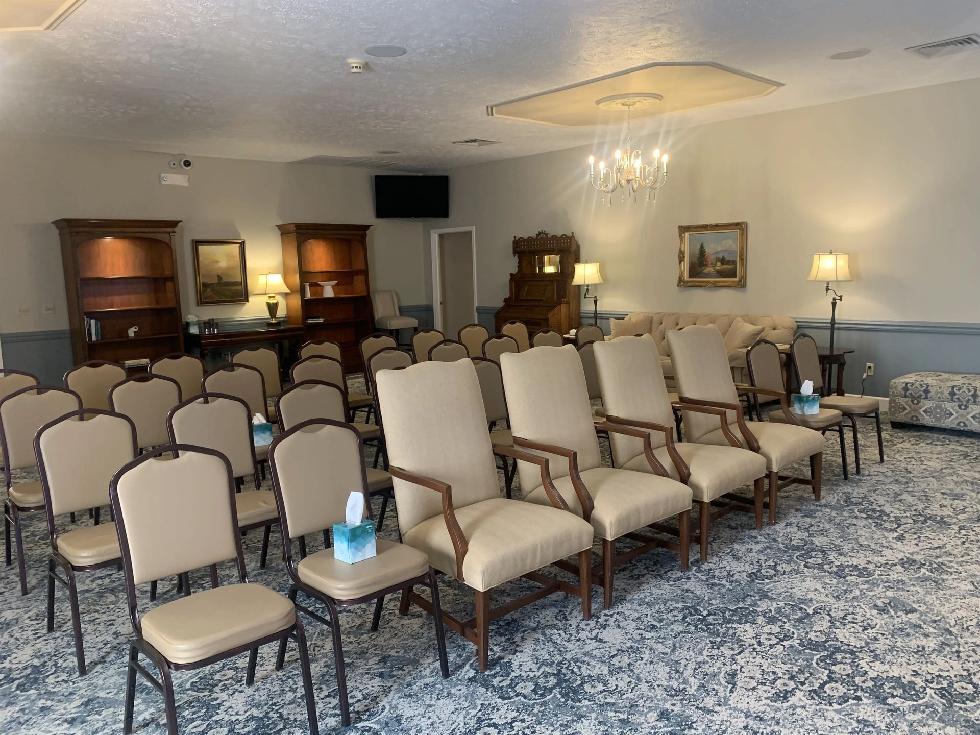 a room filled with rows of chairs and a chandelier .