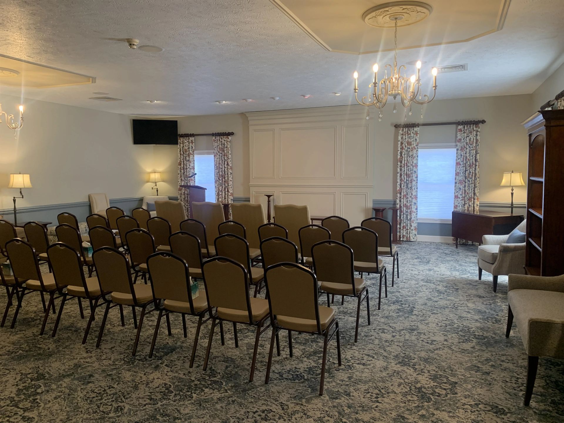 a room filled with rows of chairs and a chandelier .
