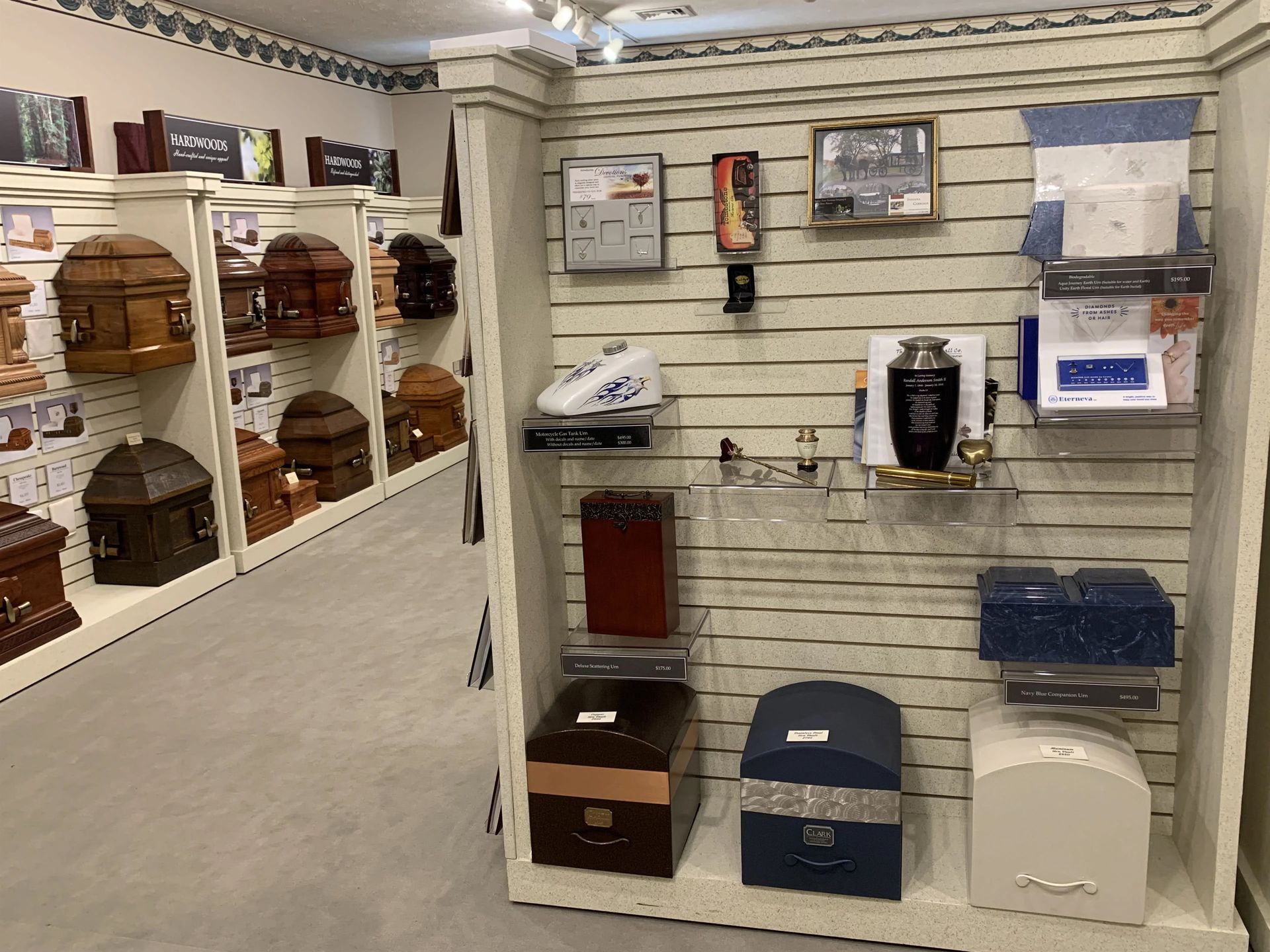 a display of coffins and urns in a funeral home .