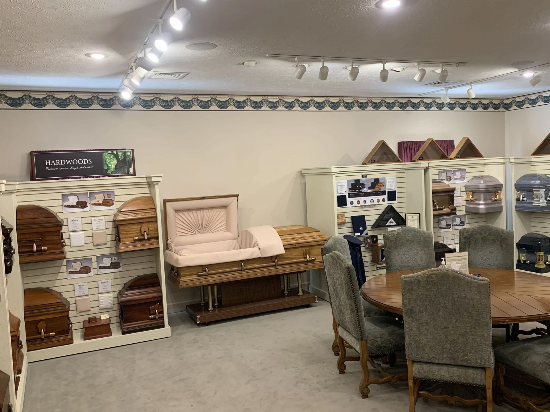 a room with a table and chairs and a display of coffins .