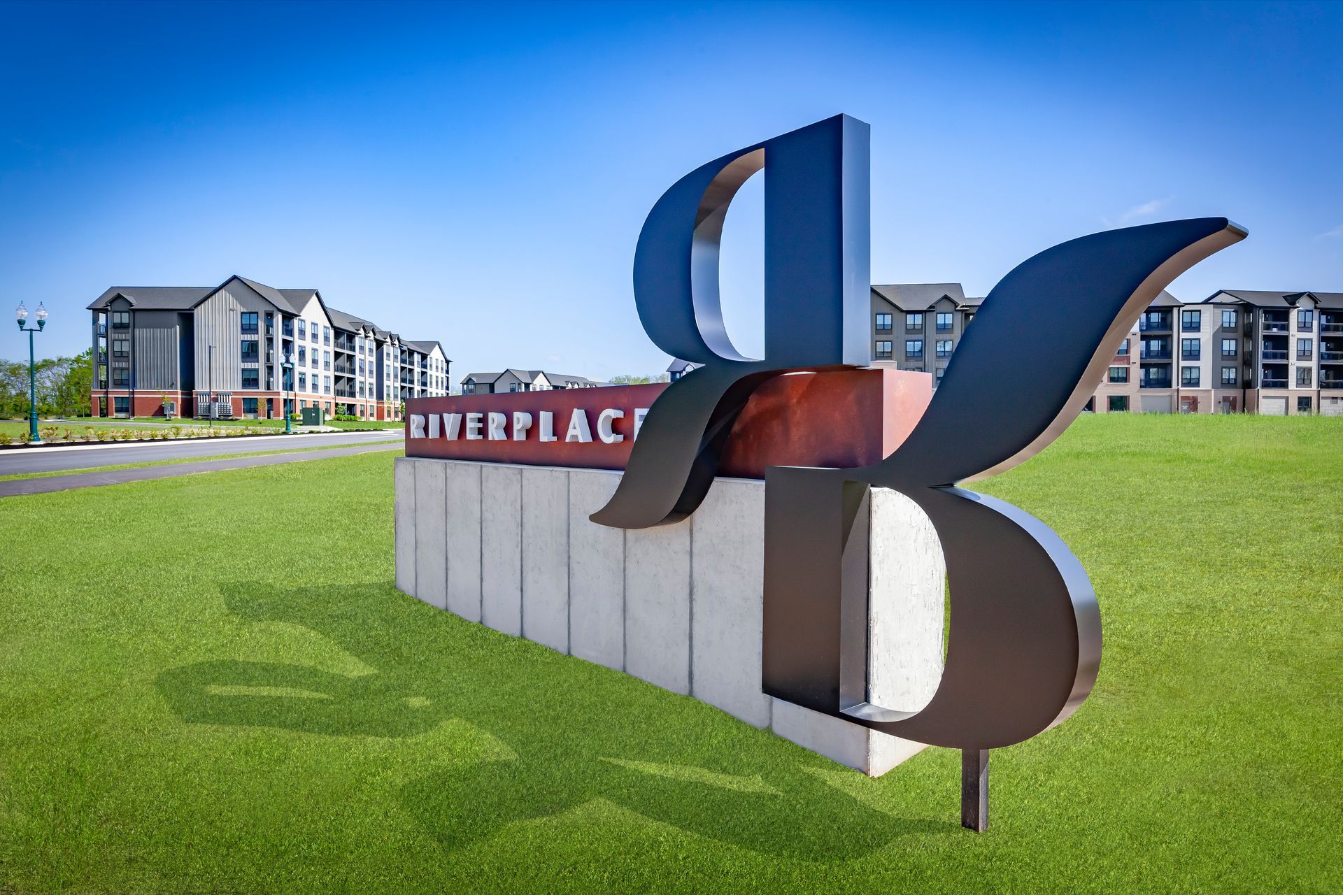 Sign for Riverplace apartments, featuring large stylized 