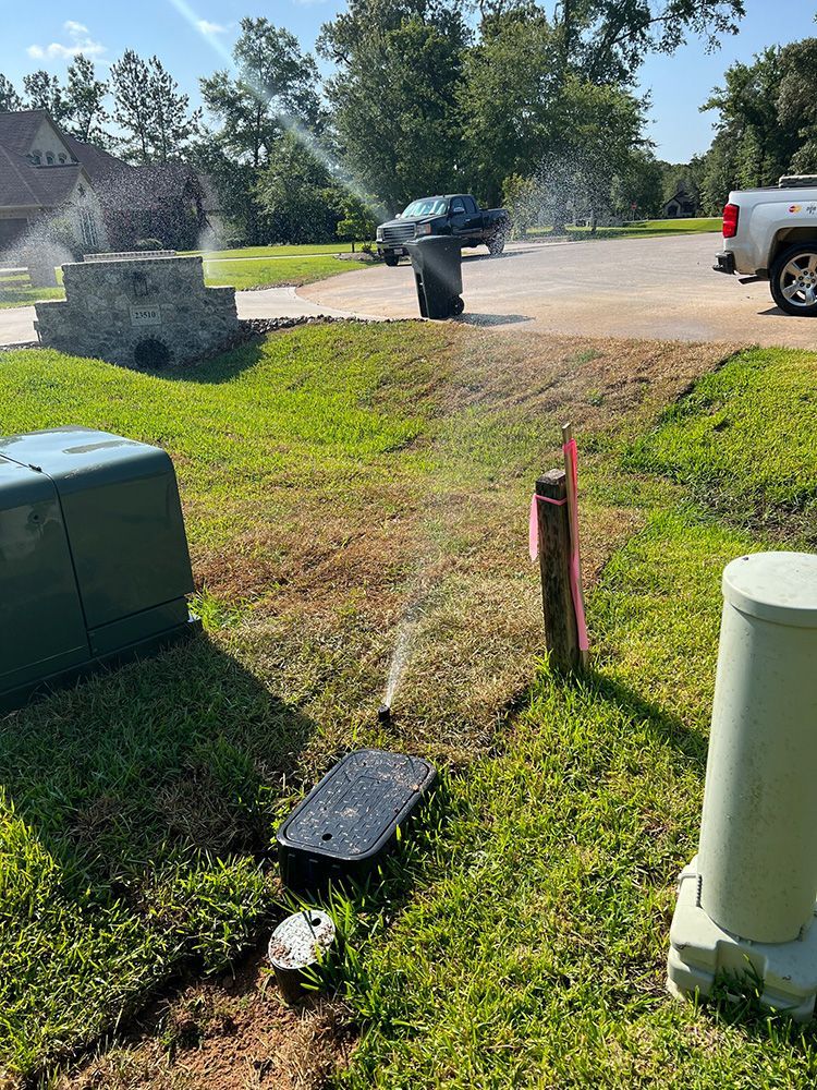 A sprinkler is spraying water on a lush green lawn.