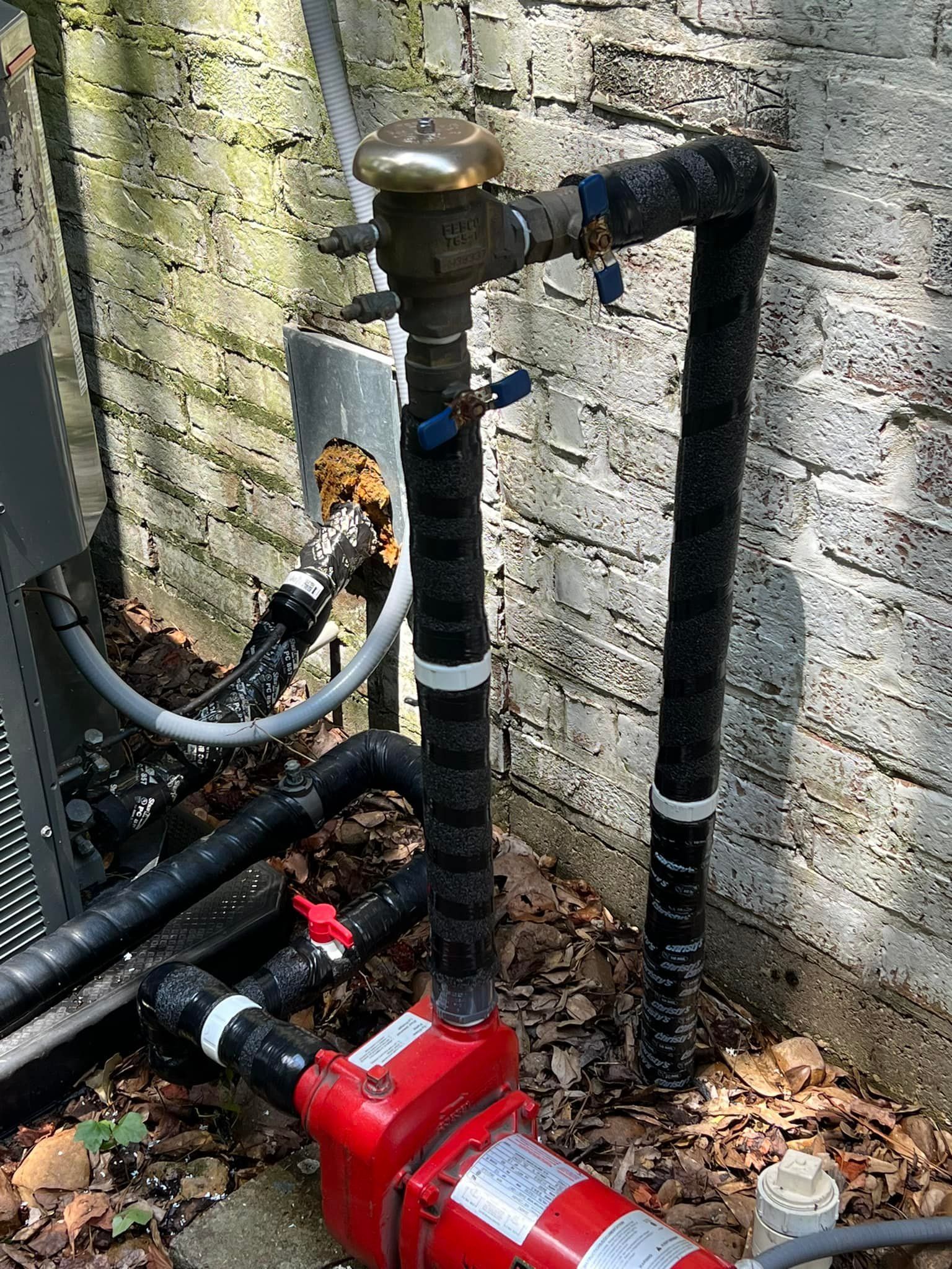 A close up of a water pipe next to a brick wall.
