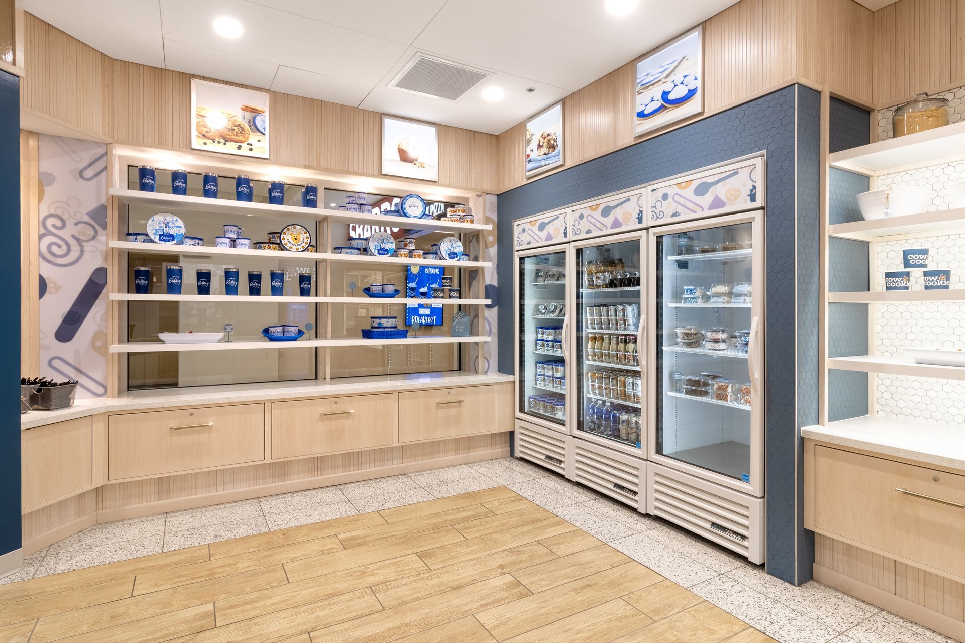 Penn State Cow & Cookie's display with blue-lit glass refrigerators and wood shelving in a clean store interior