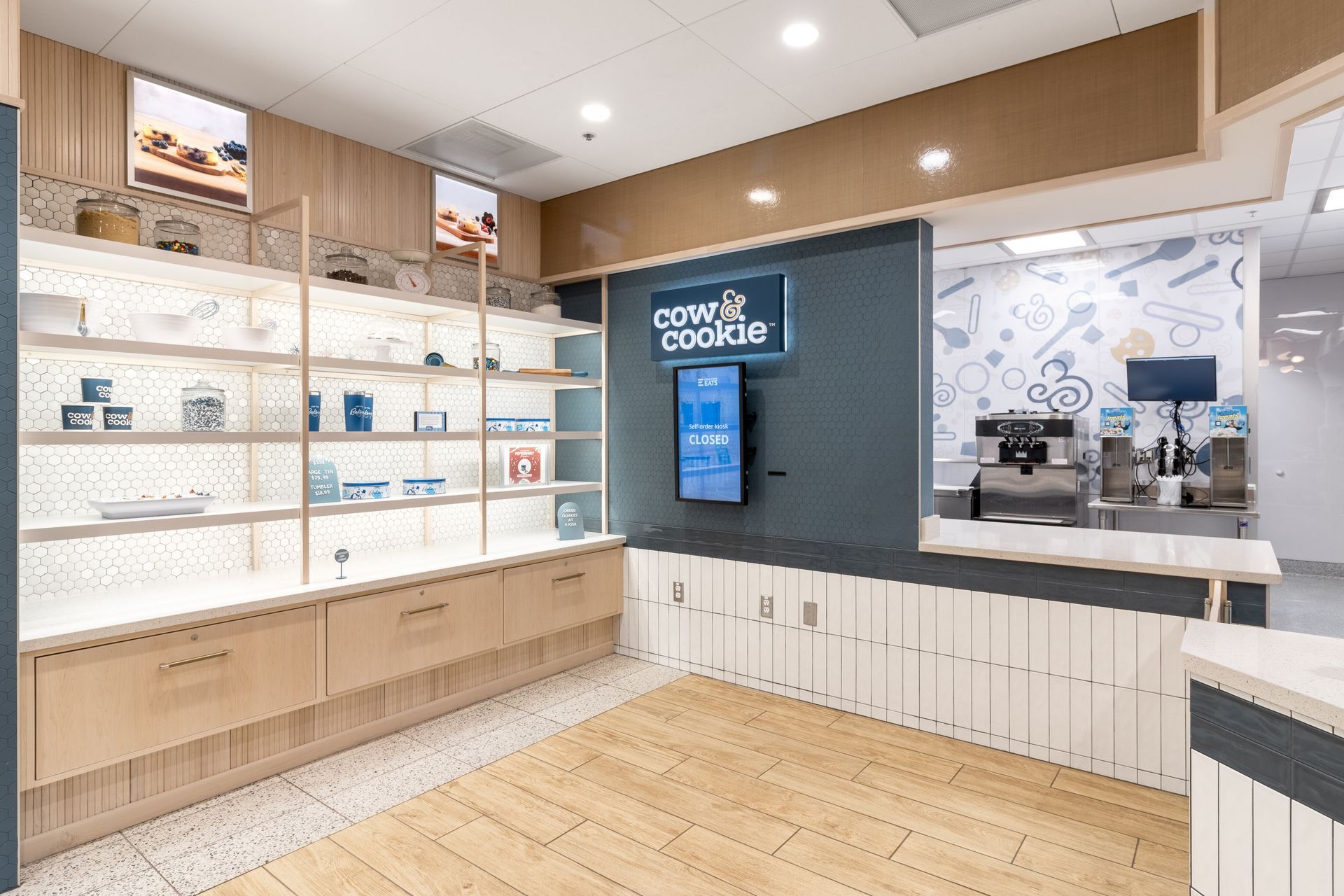 Penn State Cow & Cookie's interior with glass display shelves, white cabinets, and a coffee counter.