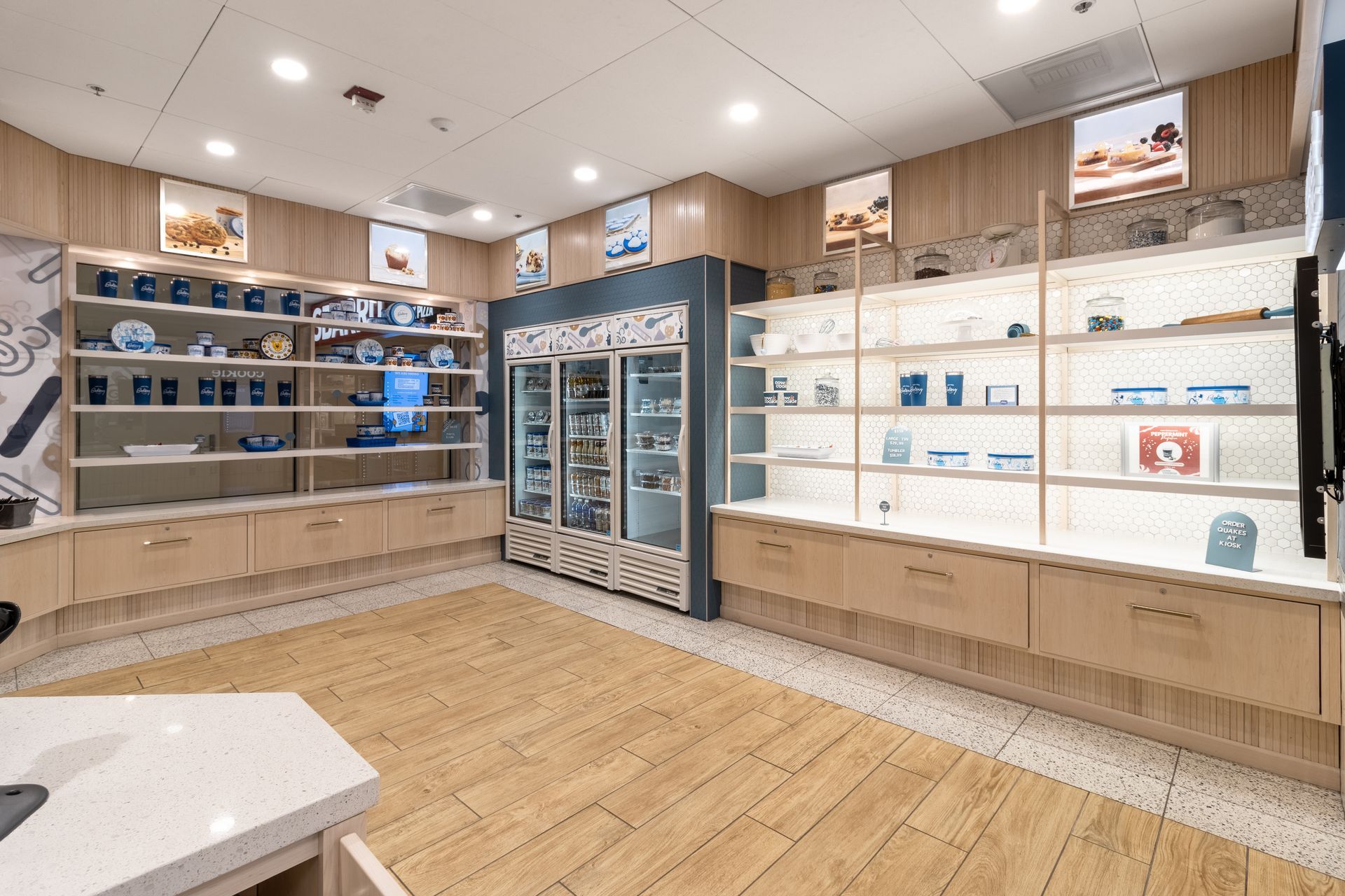 Penn State Cow & Cookie's interior with wooden flooring, glass display cases, and shelves of small boxes and products