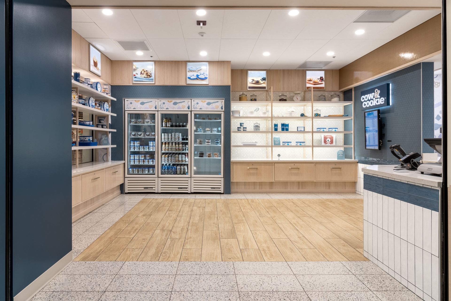 Penn State Cow & Cookie's interior with wood flooring, glass display cases, and a counter on the right