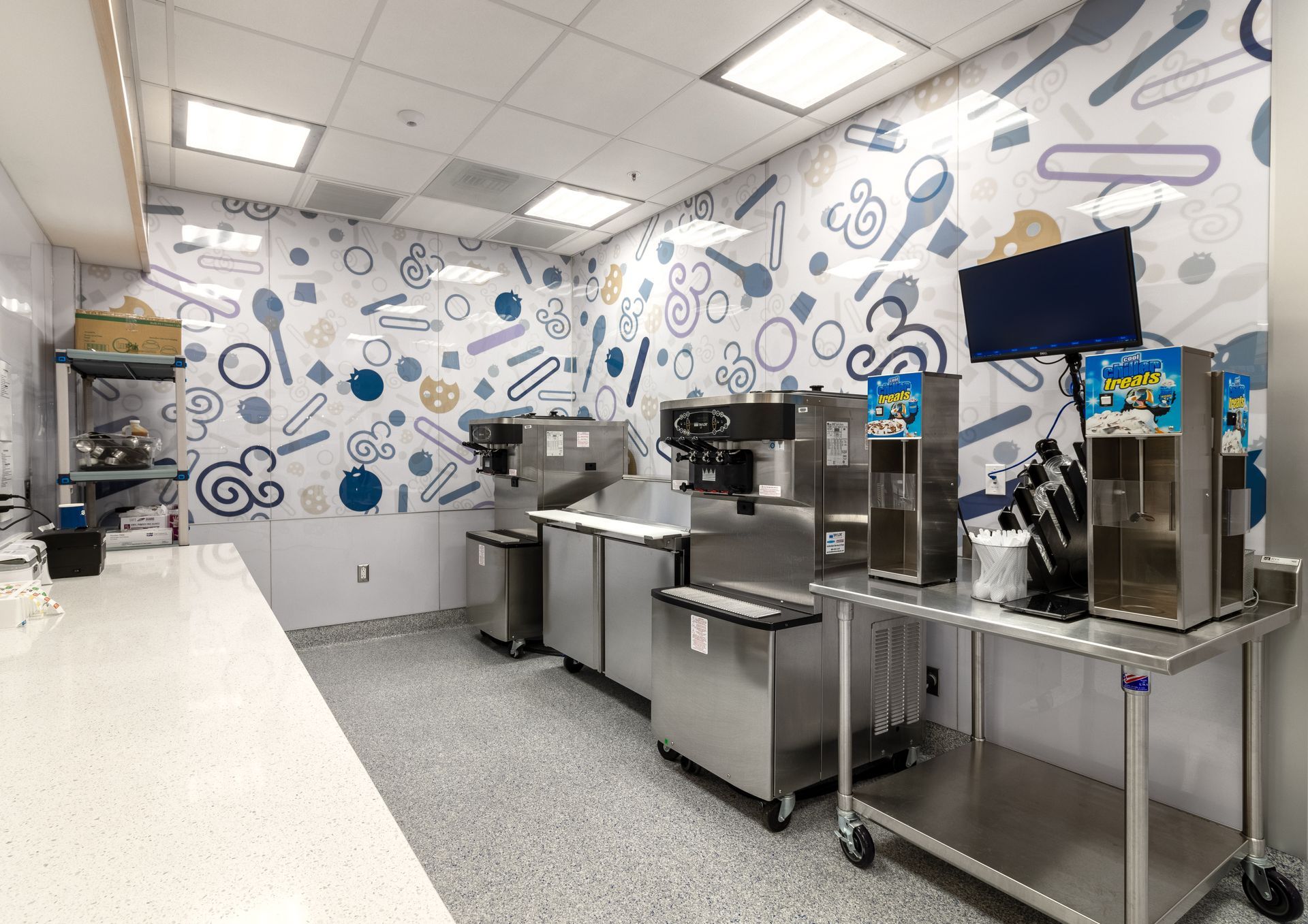 Penn State Cow & Cookie's self-serve kitchen with stainless steel equipment and a blue-patterned wall.
