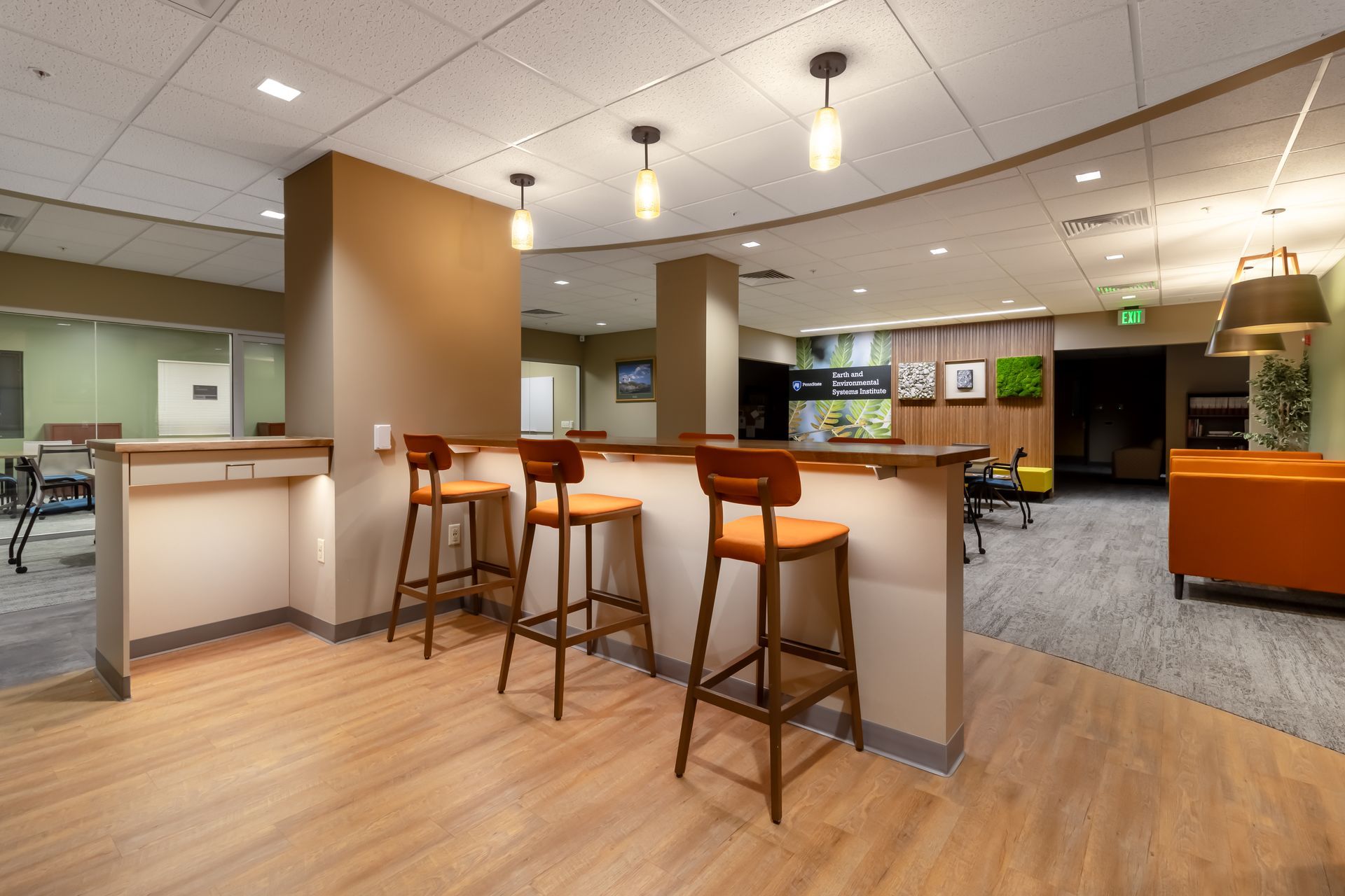 Penn State EESI Suite's modern office lounge with high stools, wooden floor, and bright open seating area