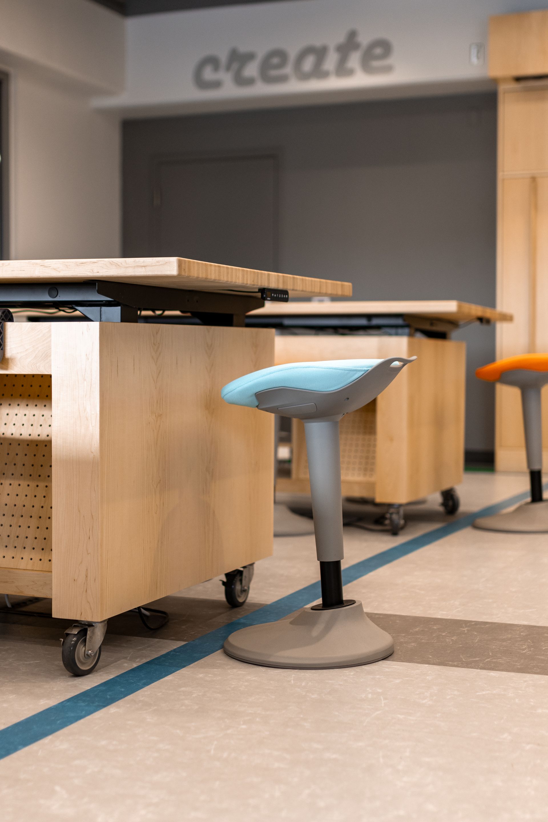 Wooden work tables on wheels with adjustable stools in a creative space with