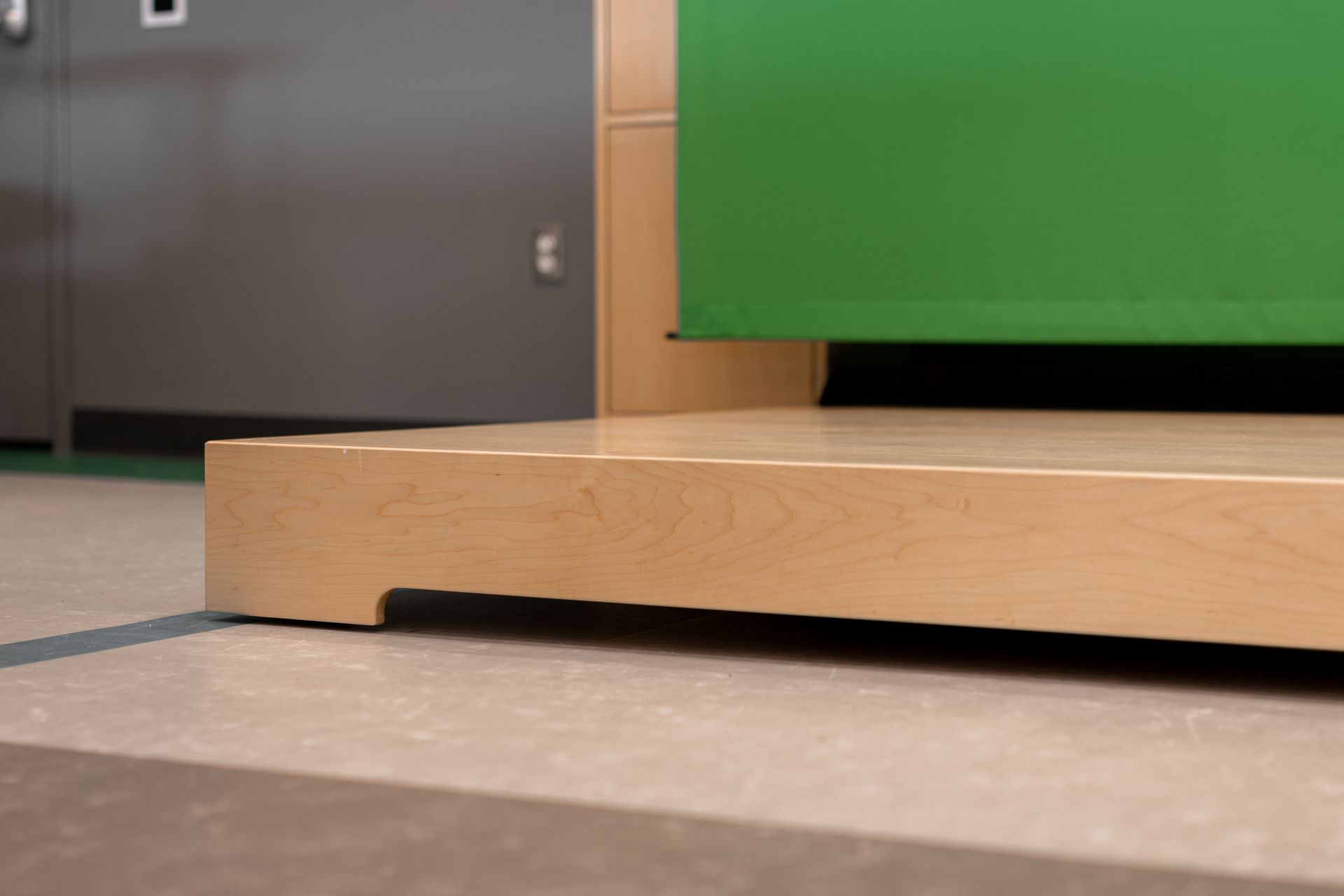 Wooden podium with green backdrop.