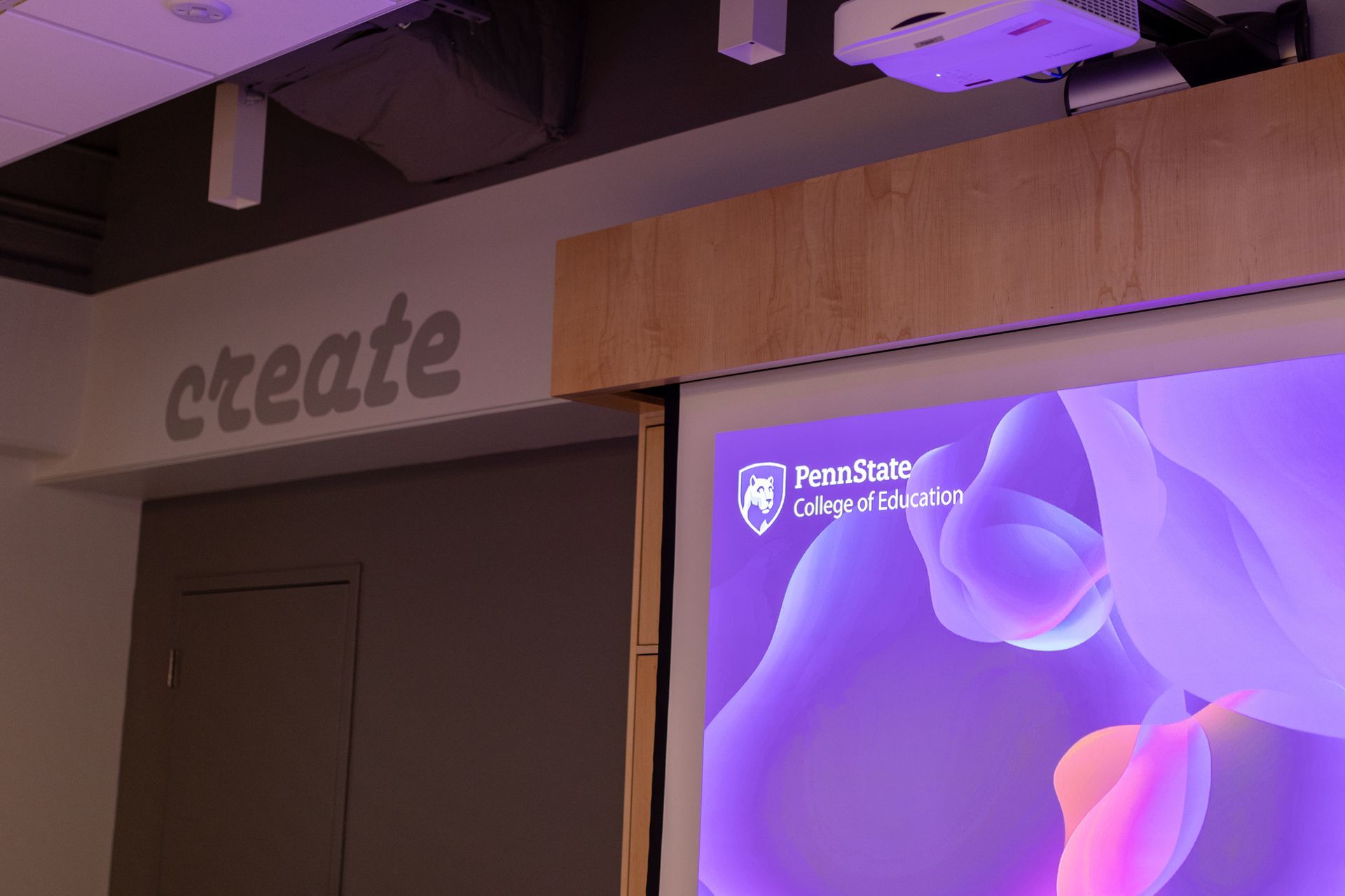 Room with a screen displaying a purple and pink abstract design,