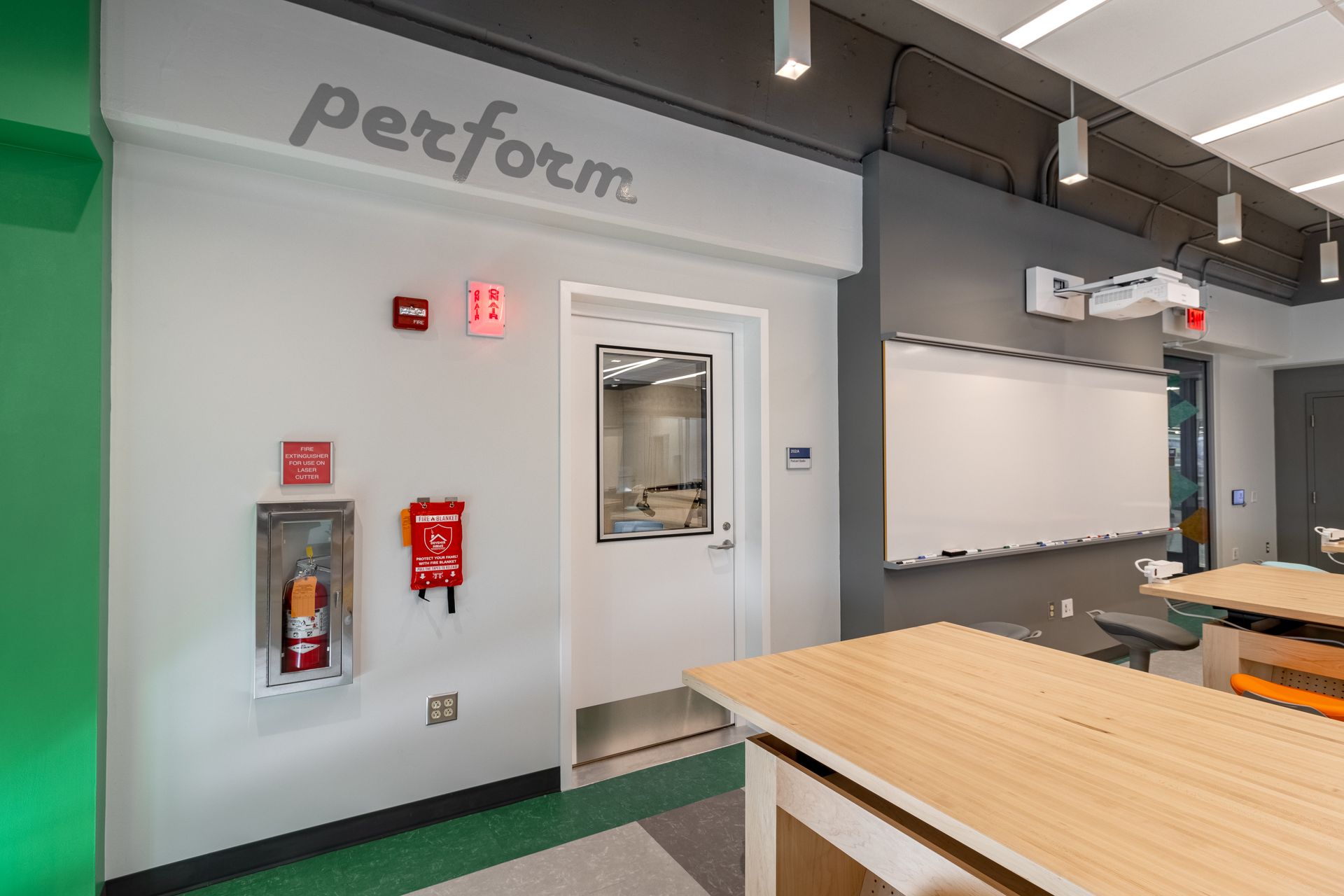 Classroom interior with whiteboards, a door, and