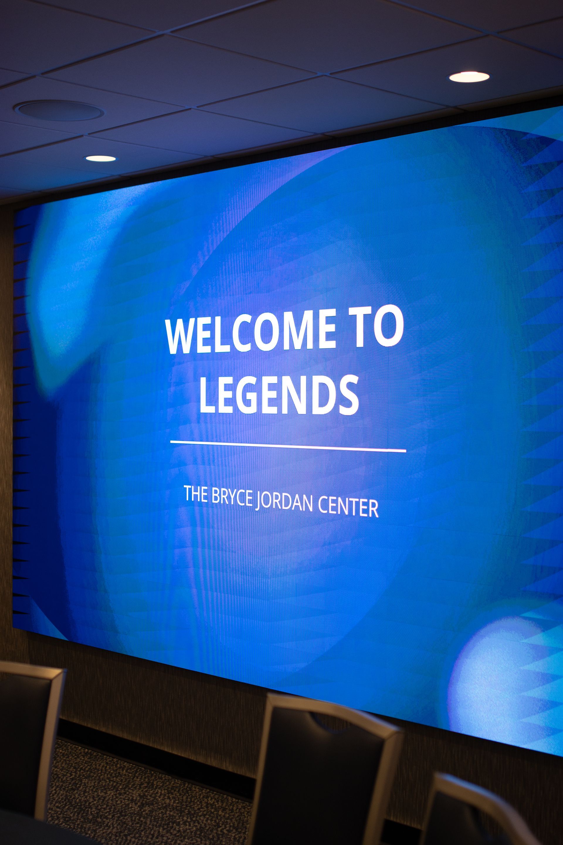 Bryce Jordan Center's blue event screen reading “WELCOME TO LEGENDS” in a dim indoor venue