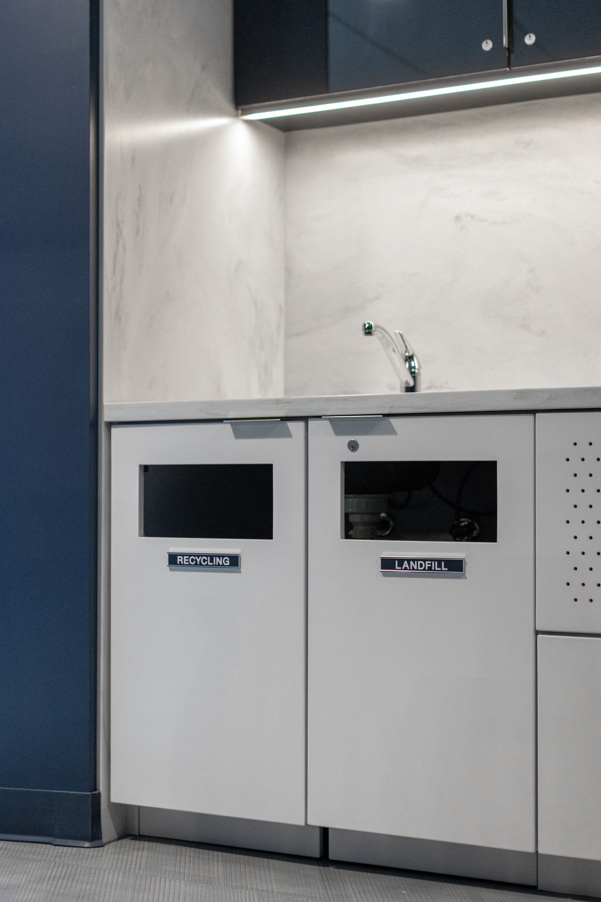 Bryce Jordan Center's modern kitchen corner with two built-in trash bins and a small sink under a counter