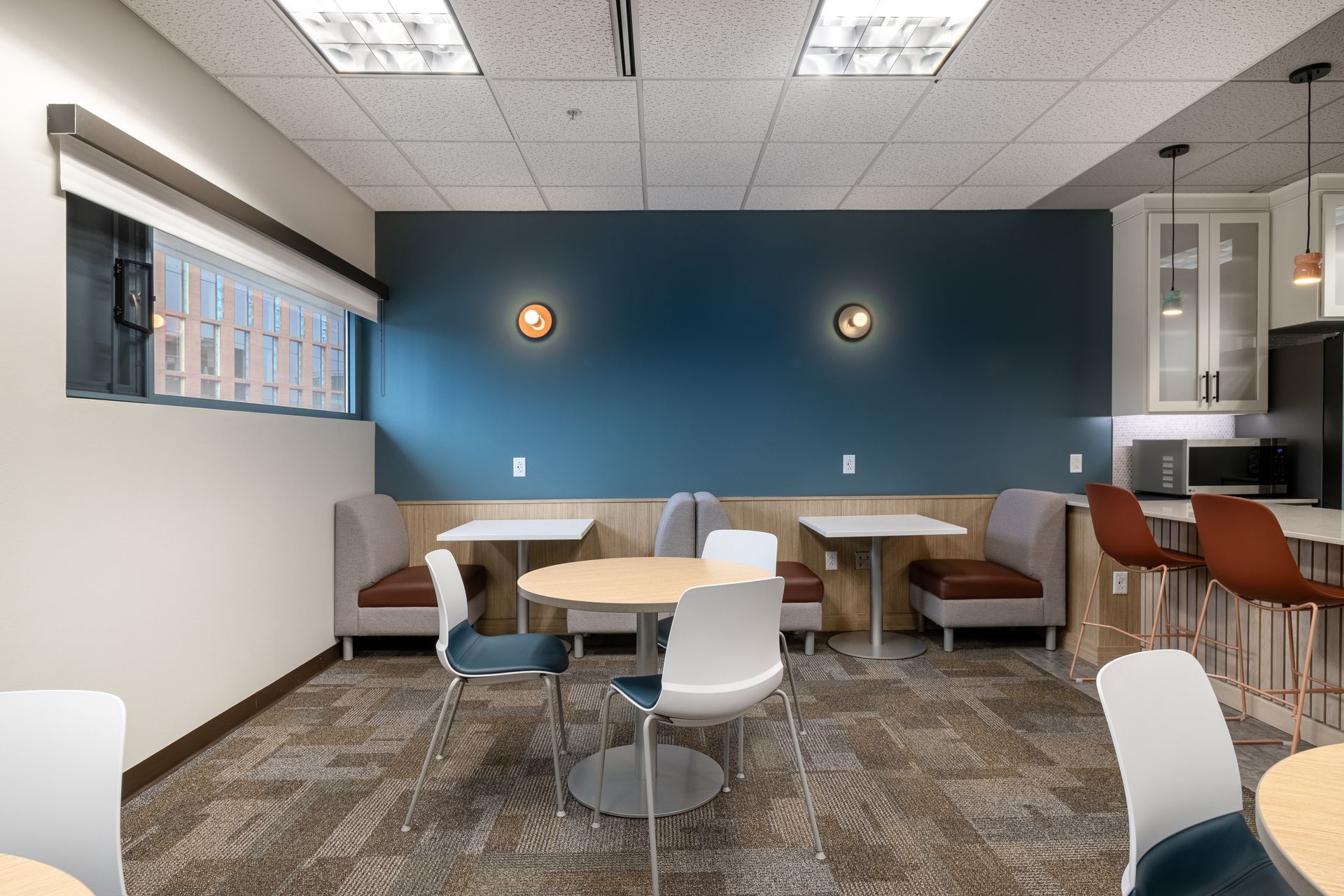 Penn State Earth and Engineering Sciences kitchen with a teal accent wall, booth seating, small tables, chairs, and a small kitchenette.