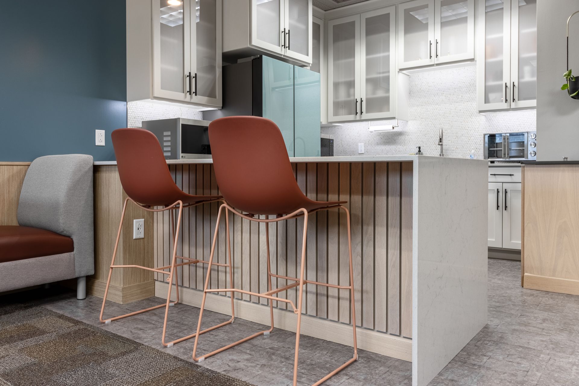 Penn State Earth and Engineering Sciences kitchen with two copper-framed, rust-colored bar stools sits in front of a white tiled backsplash.