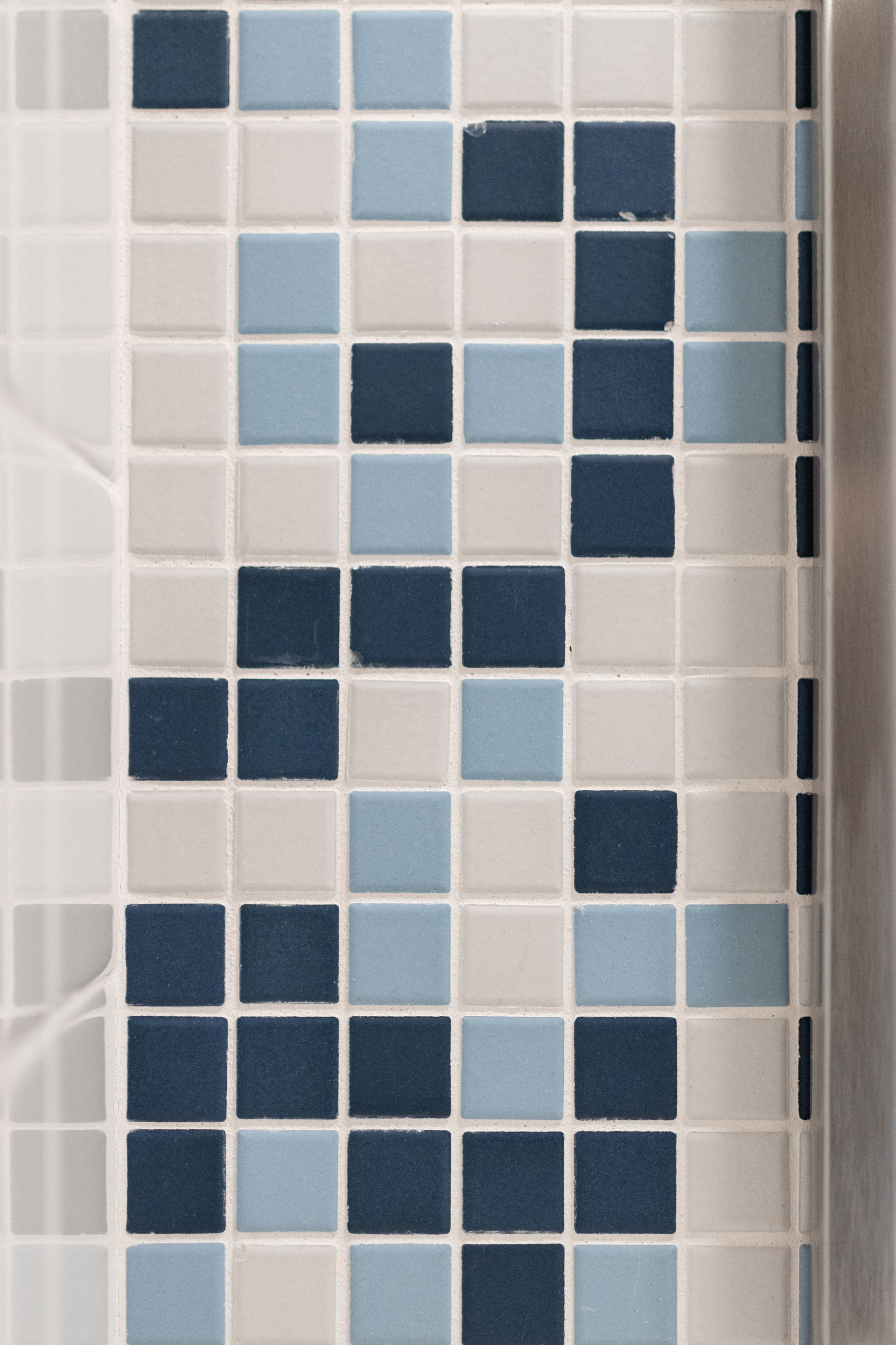 Hamilton Hall bathroom's blue and white mosaic tile wall with a repeating geometric pattern