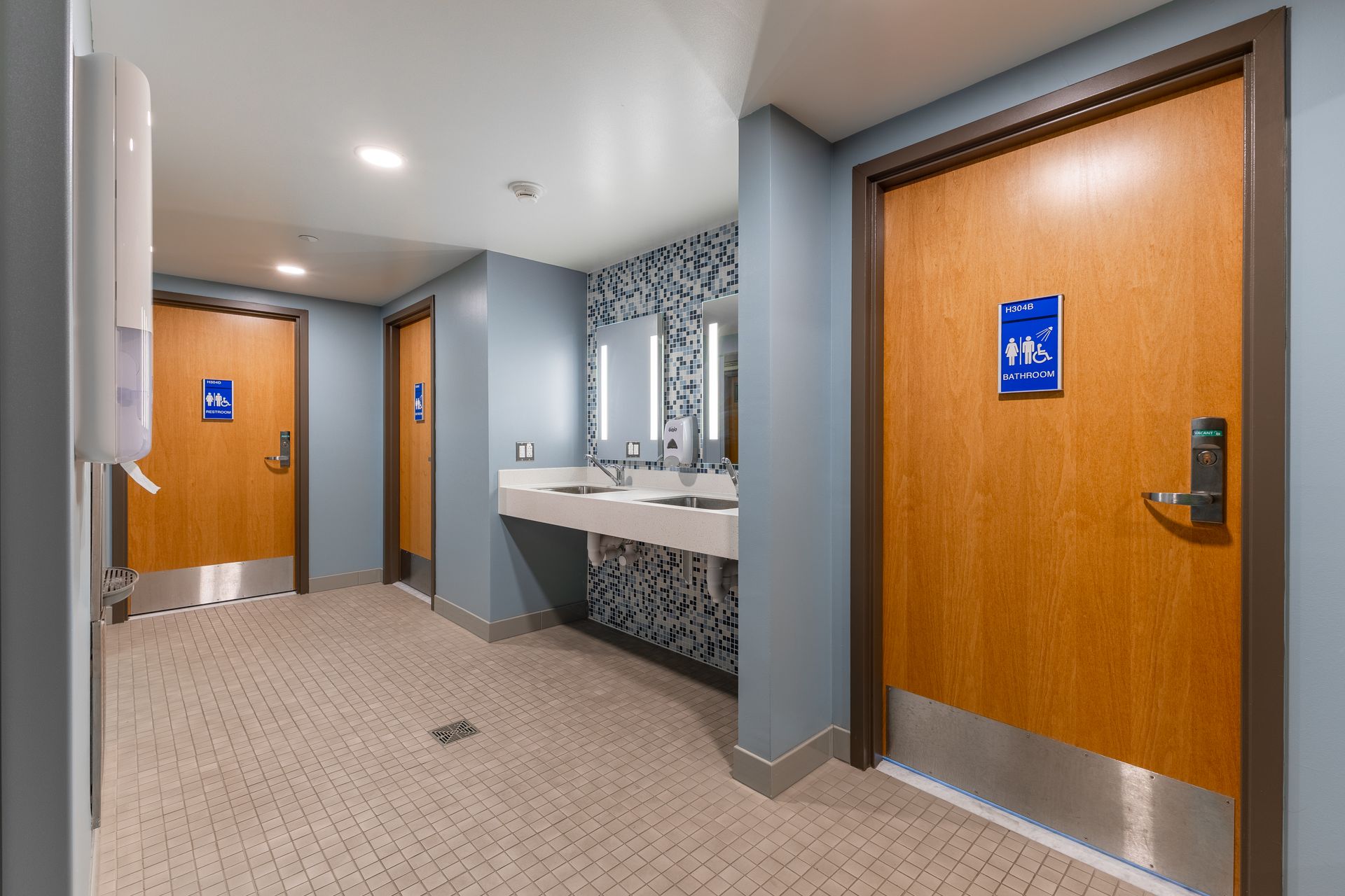 Hamilton Hall bathroom with two wooden doors and a bathroom vanity beneath a mirror