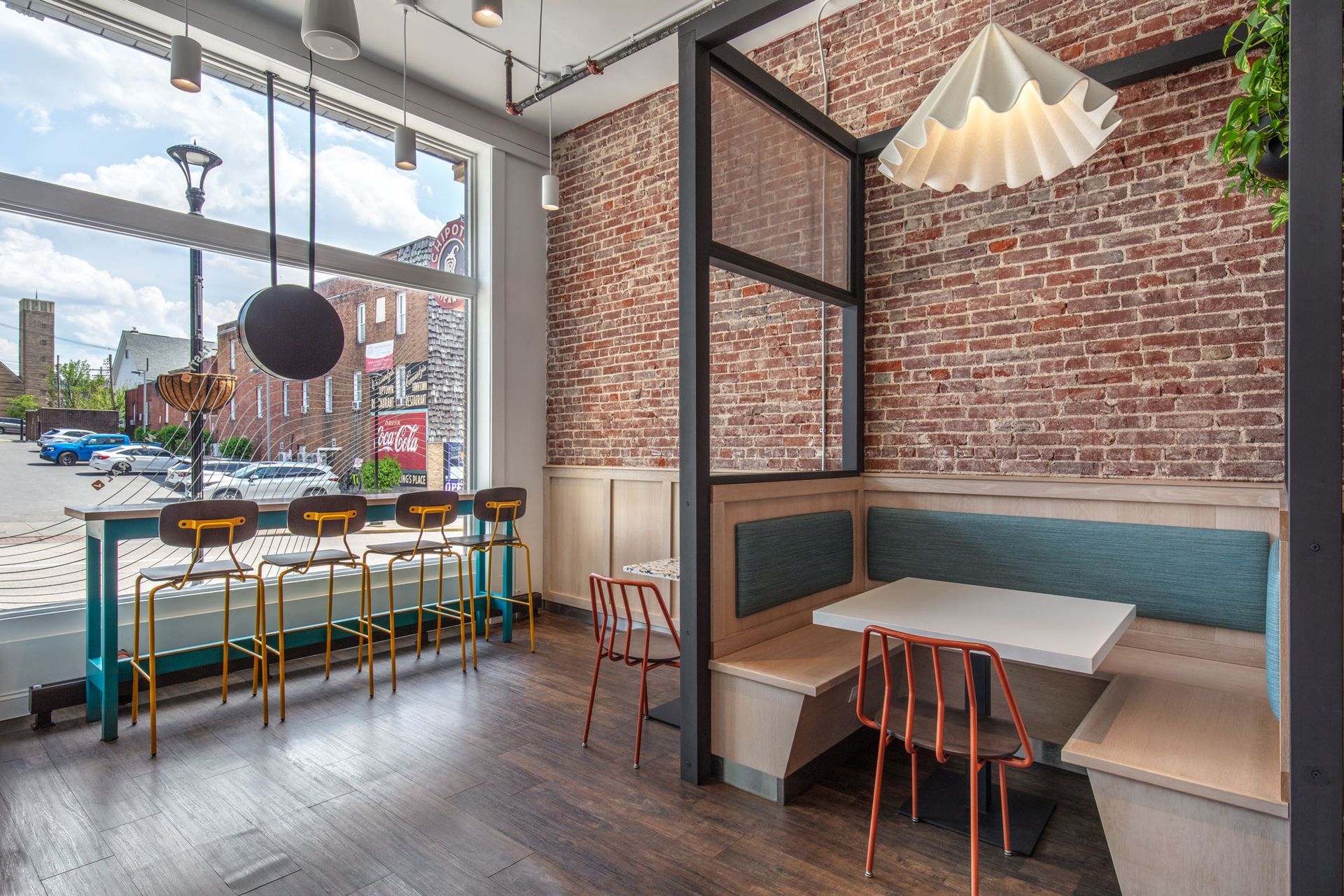 Roots Natural Kitchen's interior with brick walls, teal booth seating, and large front windows.