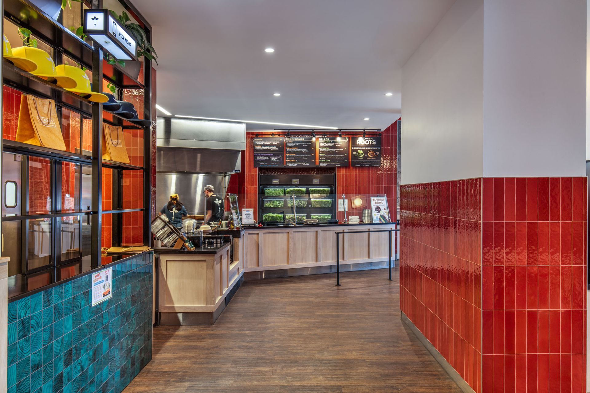Roots Natural Kitchen's interior with tiled walls, display cases, and a counter in the back