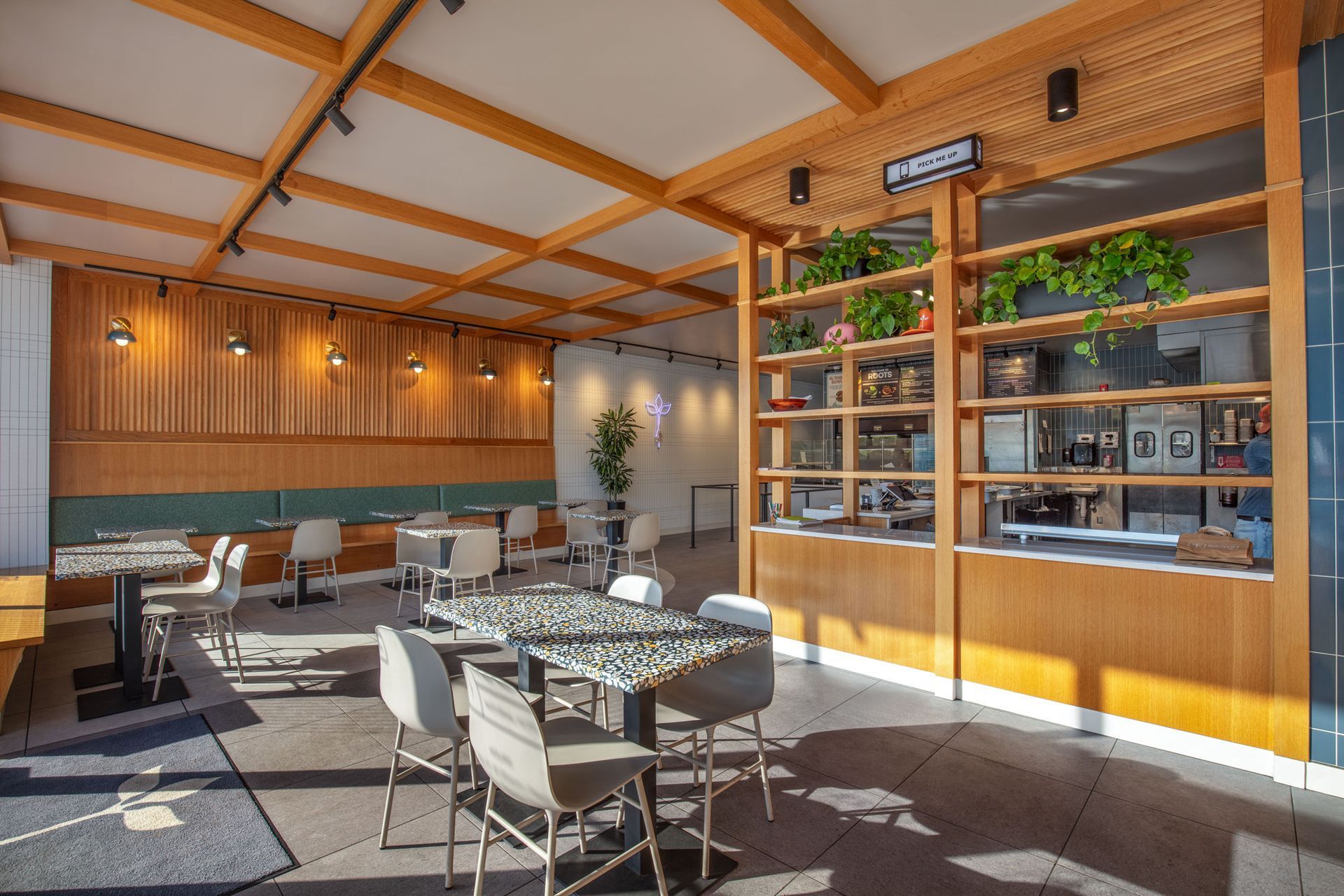Roots Natural Kitchen's interior with wooden beams, round tables, and sunlight through large windows