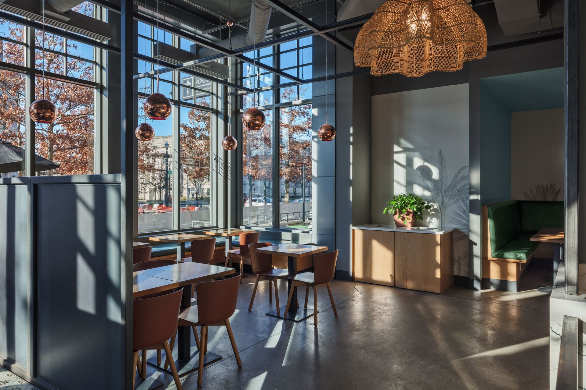 Roots Natural Kitchen's tall windows, wicker pendant lights, and wooden tables and chairs