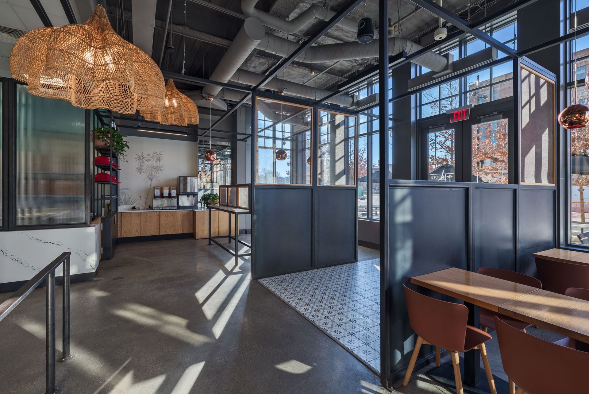 Roots Natural Kitchen with industrial decor, desks, glass partitions, and warm hanging lights