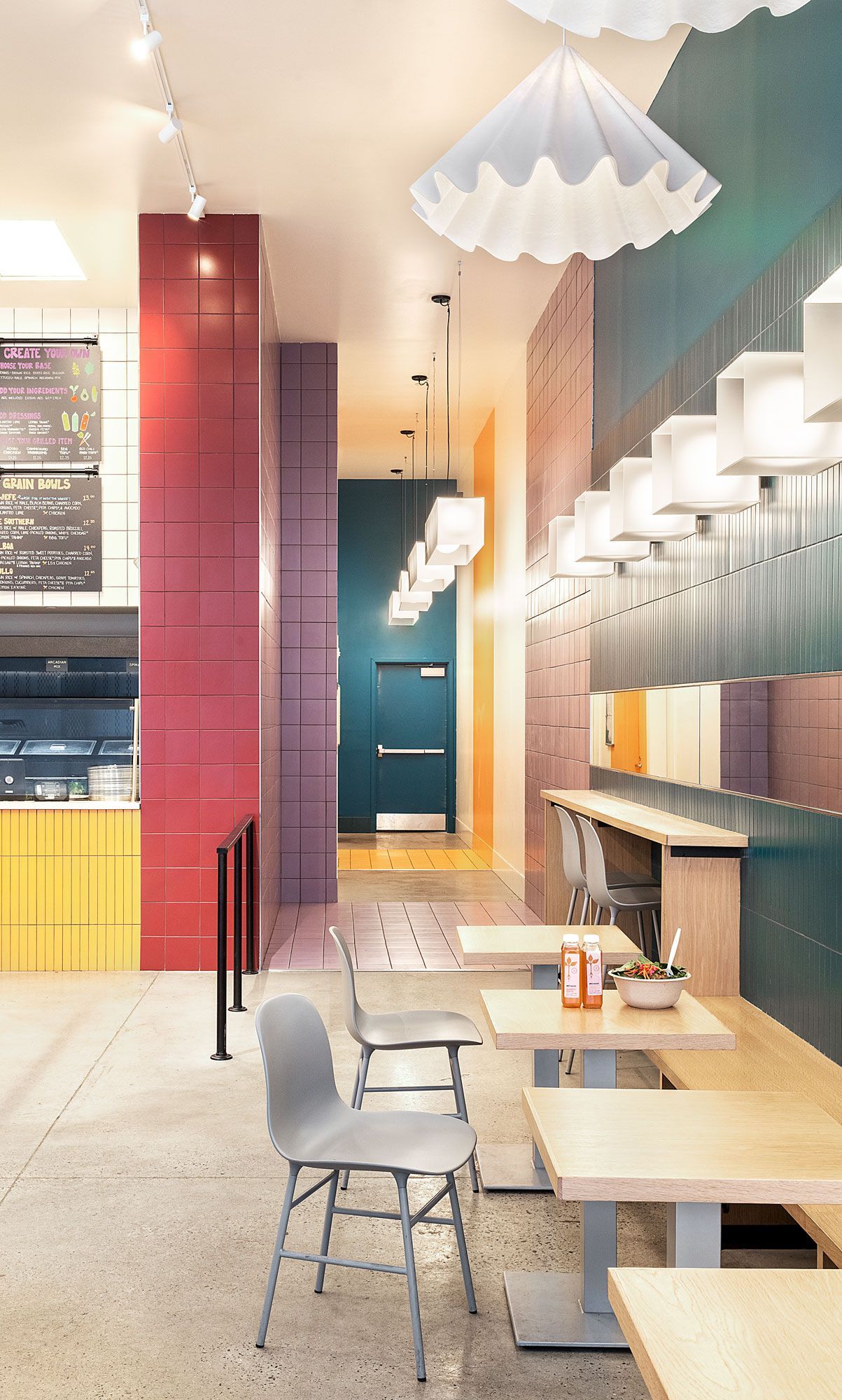 Restaurant interior: tables, chairs, colorful walls, and lights.