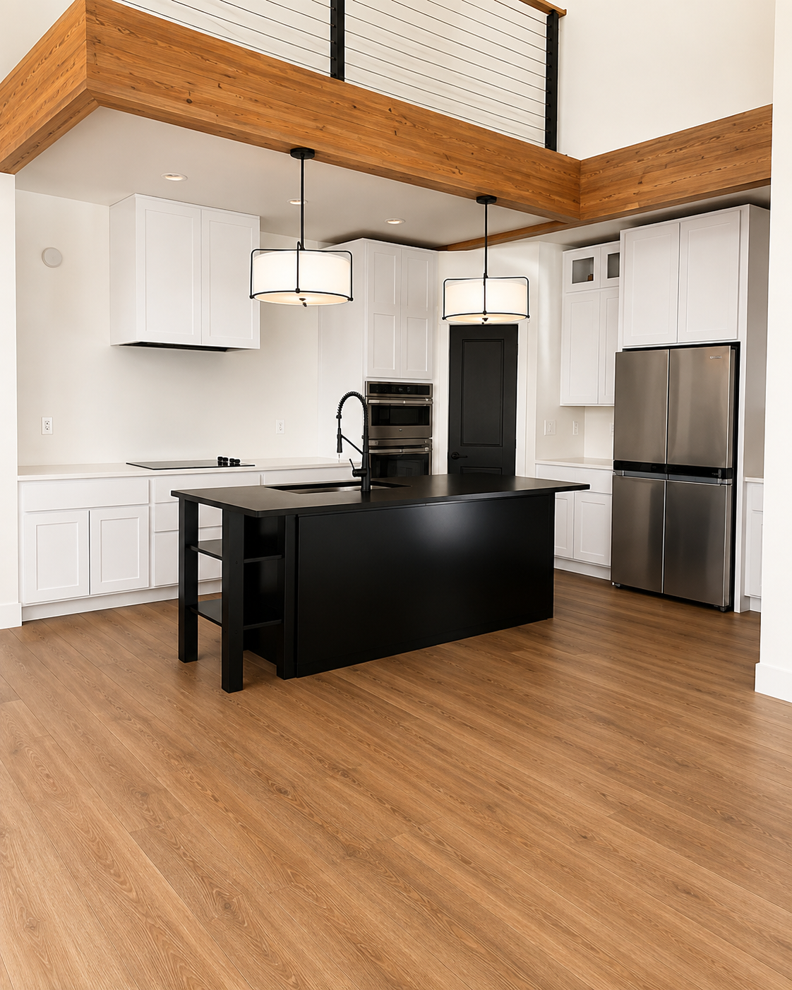 Modern kitchen with black island, stainless steel fridge, white cabinets, and wood floors.