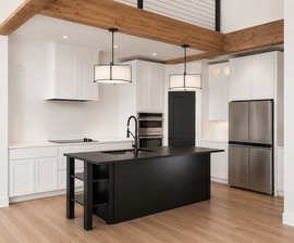 Modern kitchen with white cabinets, wood ceiling beams, black island, and stainless steel appliances