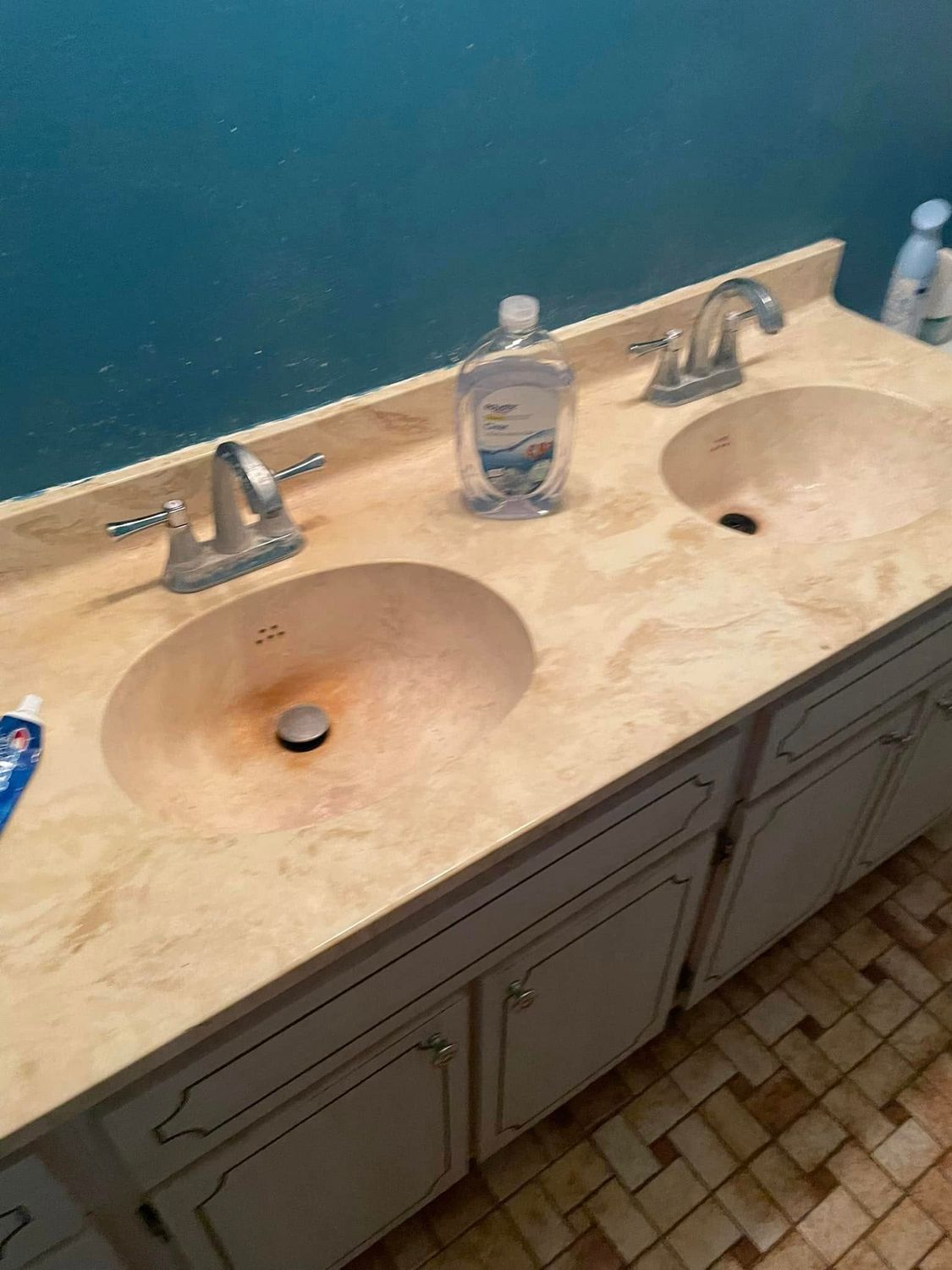 Bathroom double sink vanity with a beige countertop and two soap dispensers on it