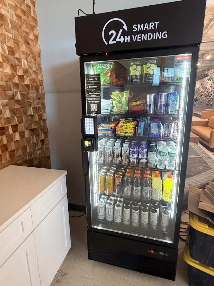 Snack vending machine with illuminated glass front and assorted drinks and chips inside