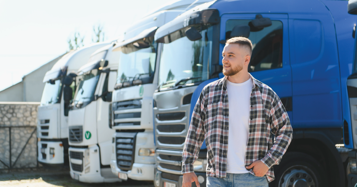 Man standing in front of blue and white trucks in a lot