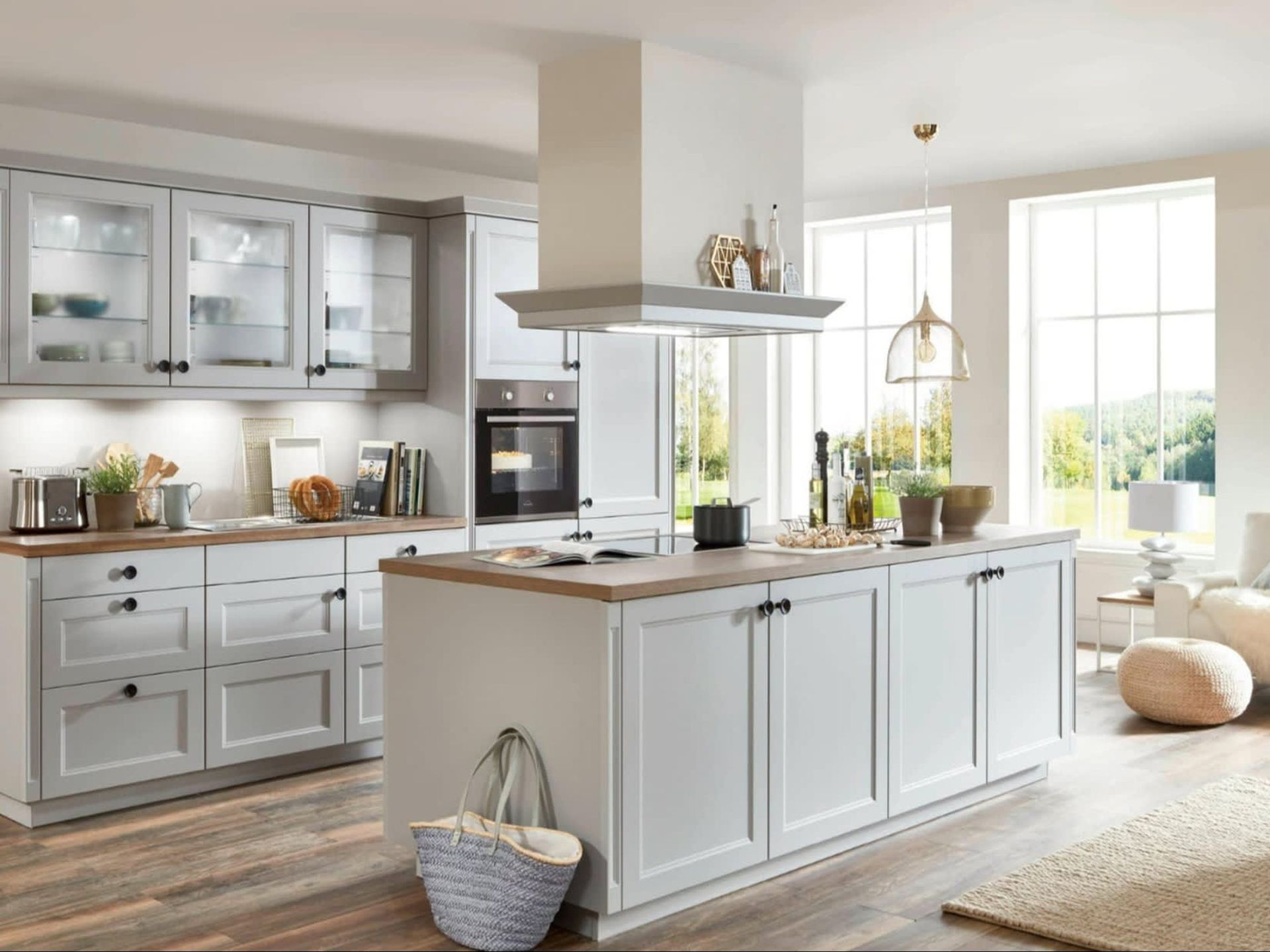 Bright modern kitchen with white cabinets, large island, wood accents, and sunlit windows