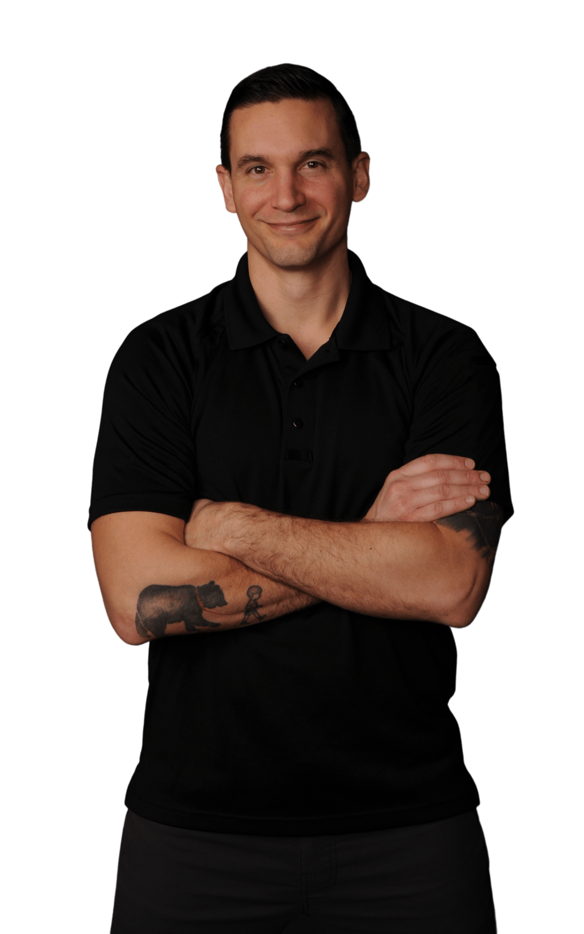 A man with a tattoo on his arm is standing with his arms crossed.