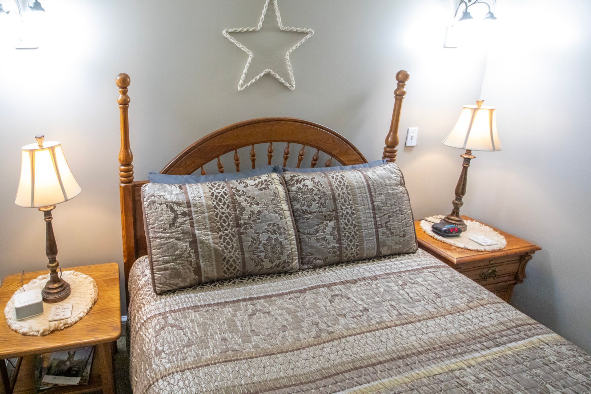 Bedroom with wooden bed, nightstands, lamps, star decoration.