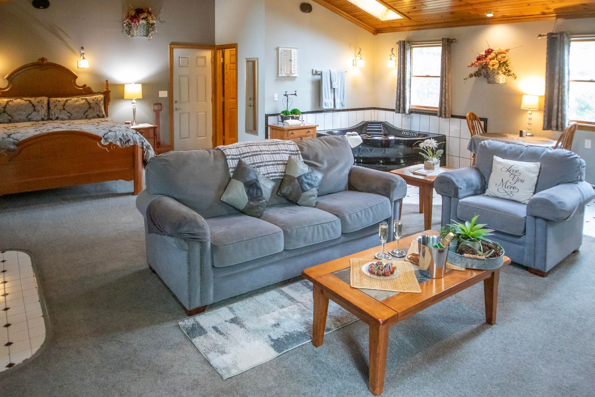 Cozy, well-lit living space with sofa, armchair, coffee table, bed, and decorative accents.