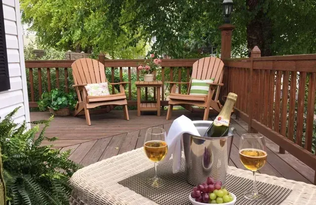 Outdoor deck with Adirondack chairs, champagne, and grapes.