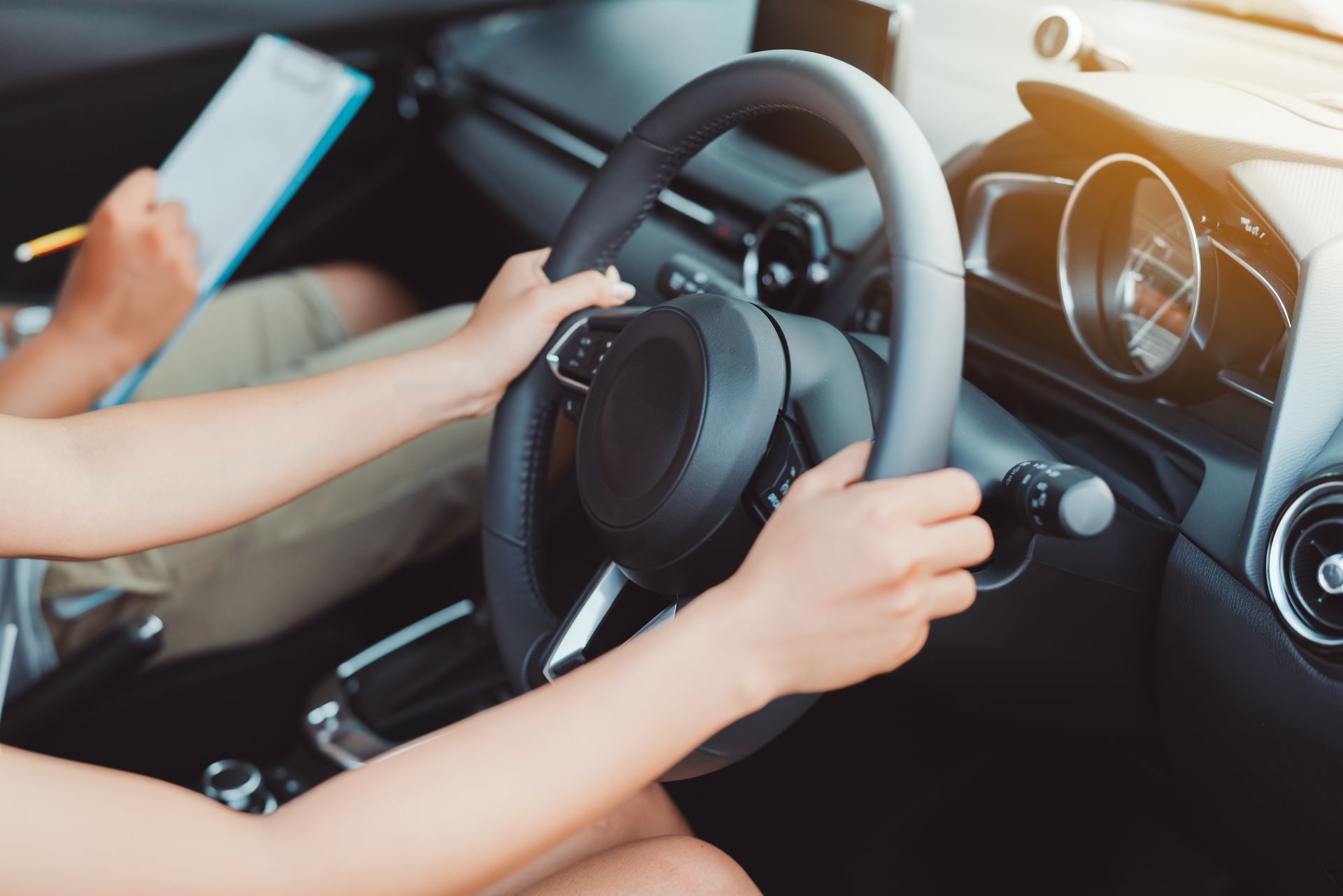 Person driving a car during a driving test with an examiner in the passenger seat.