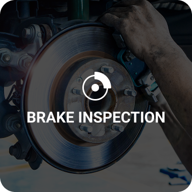 Brake rotor and caliper during inspection, with mechanic's hand; text 