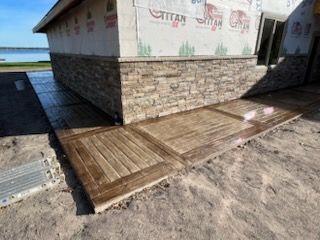 Wooden ramp and small deck beside a stone-sided building near the water