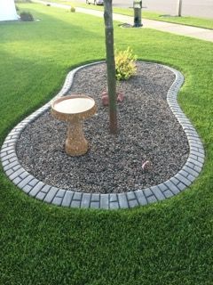 Curved sidewalk curb ramp with yellow tactile warning strips and gray concrete at a street corner